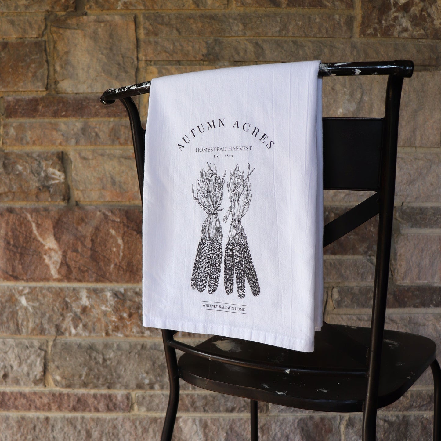 homestead harvest autumn acres corn bundle illustration tea towel black and white. tea towel is hung over back of chair