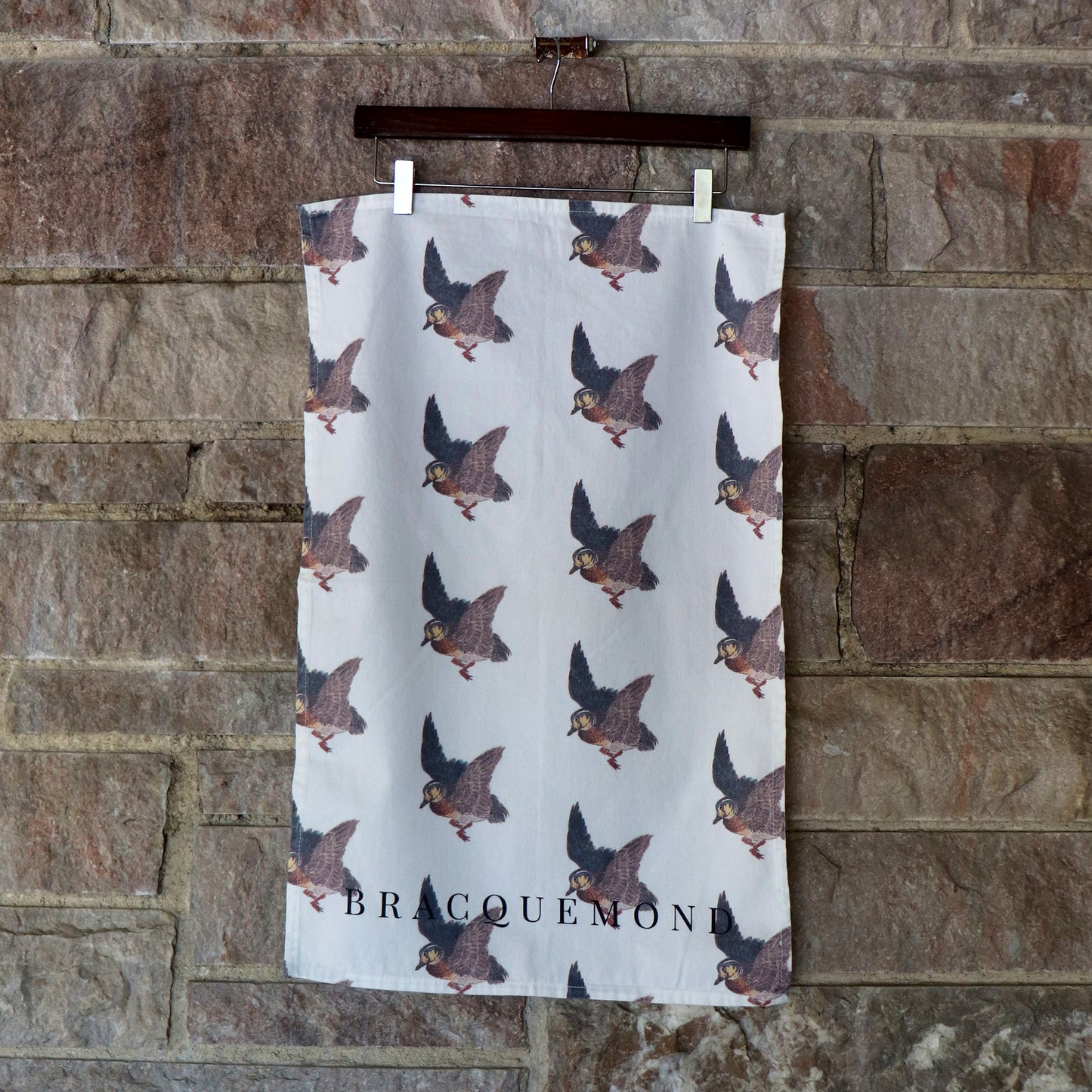 Close-up of a hanging cotton kitchen towel displaying a beautifully detailed etching of a flying duck.