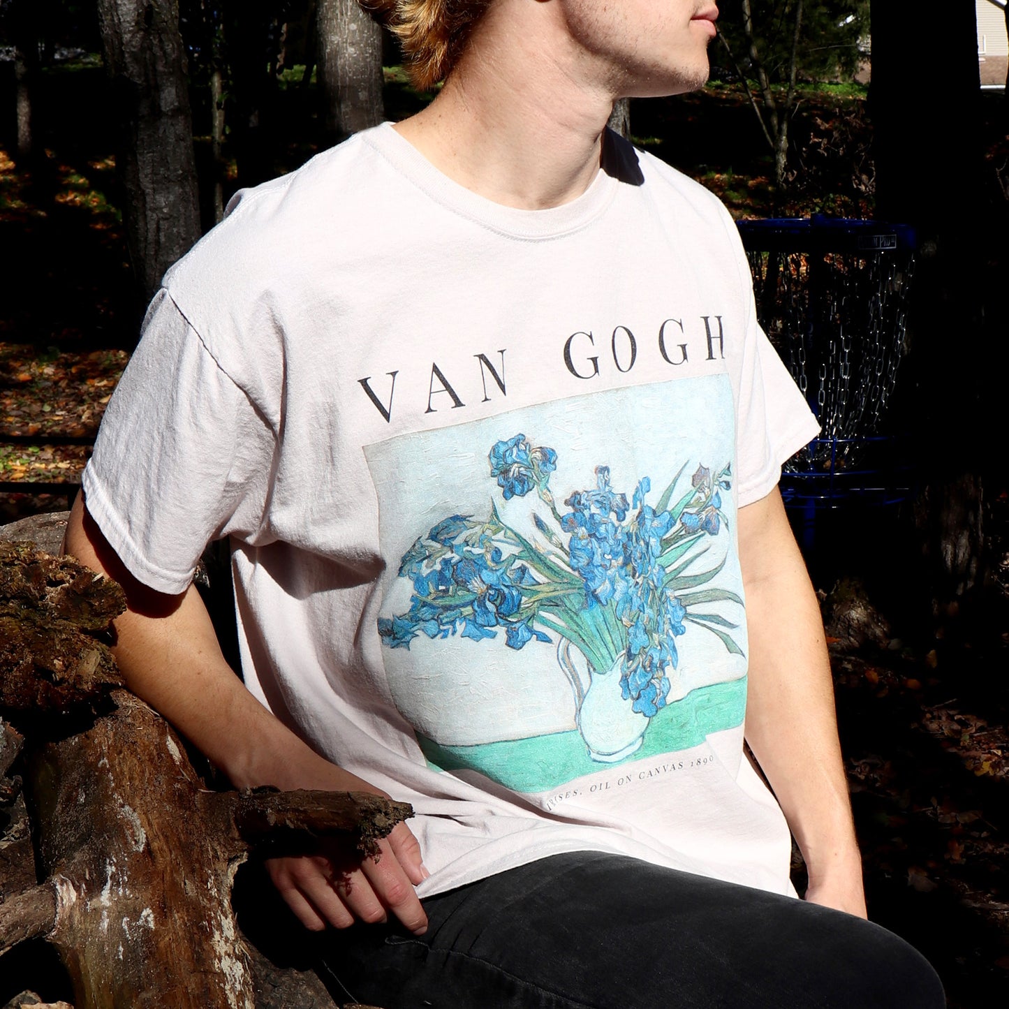 man sitting on wood log wearing vincent van gogh irises tshirt in the color sand by whitney baldwin home